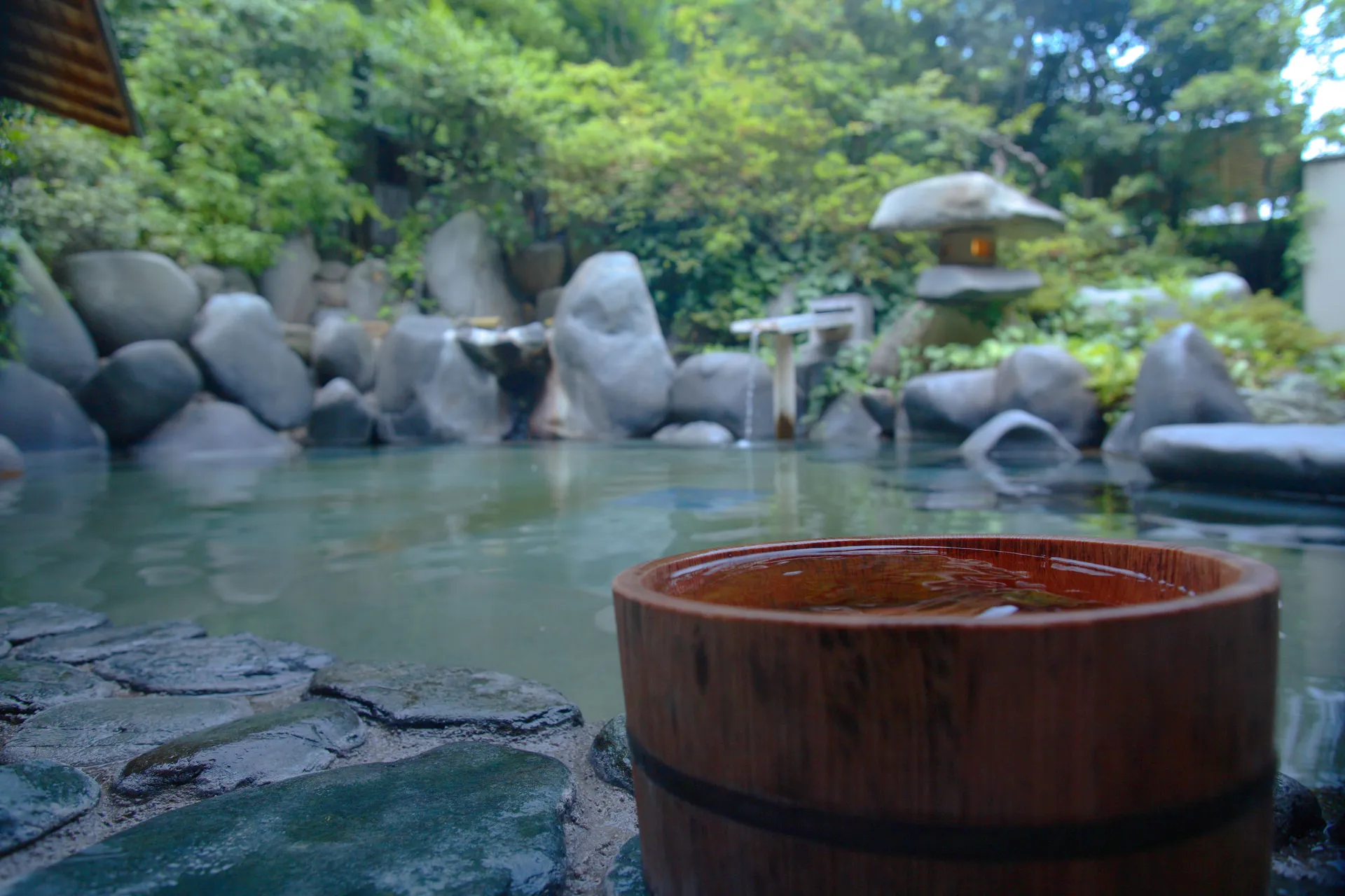 Freiluftbad mit Felsen und Steinlaterne in Tamatsukuri Onsen